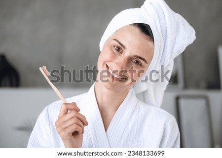 Oral hygiene and dental care concept. Portrait of smiling woman in robe holding bamboo toothbrush. Everyday brushing teeth. Healthy toothy smile Royalty-Free Stock Photo #2348133699