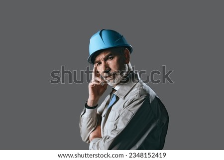 Portrait of a thoughtful elderly Caucasian worker in work clothes. Royalty-Free Stock Photo #2348152419