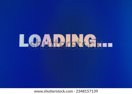 White inscription "Loading" on a blue monitor with pixels