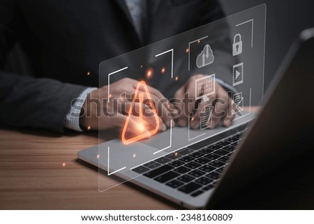Businessman using computer laptop with triangle caution warning sign or exclamation for notification error and maintenance concept.