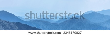Blue mountain landscape with silhouettes of hills and peaks