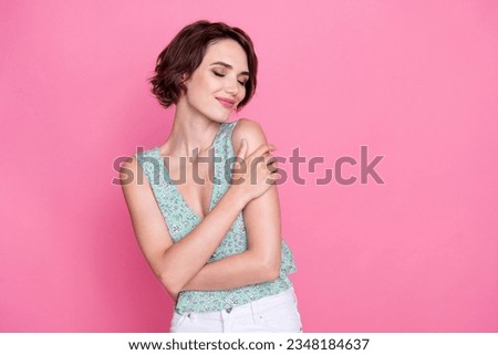 Photo of young charming lady wear trendy crop top stylish print hugs herself love comfort peaceful person isolated on pink color background