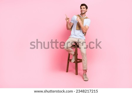 Full body photo of young guy satisfied directing fingers empty space advertise new bar students discount isolated on pink color background