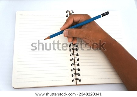 A blank white notebook and a pencil used in education for students to take notes on a white background.