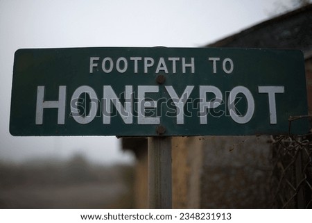 Close up of a signpost saying 'Footpath to Honeypot' on a misty morning