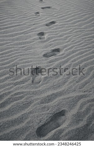 footprints crossing the barren desert