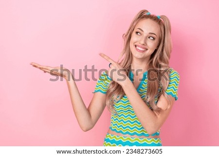 Photo of positive cute girl wear stylish clothes arm demonstrate empty space beauty salon proposition isolated on pink color background