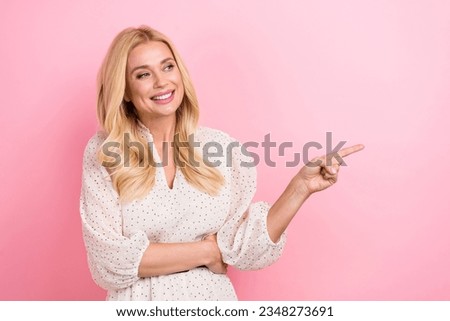 Photo of mature woman wear stylish dress look interested direct finger empty space proposition sale offer isolated on pink color background