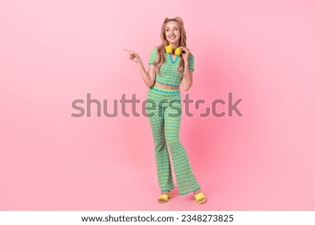Full size photo of attractive young woman point look empty space dressed stylish green print clothes isolated on pink color background