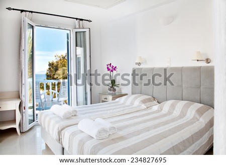 hotel room with bed and view in a beautiful blue sky and in the sea