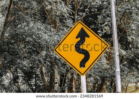 Sign curved road on the way at the natural Field Or forest. Warning attention Right curve sign at Rural highway. Road sign showing curves ahead
