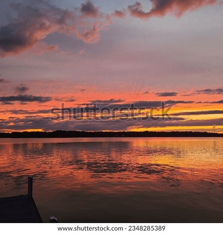 Vivid orange and blue cloudy sunset after afternoon late summer rain storm on High Rock Lake Lexington NC Royalty-Free Stock Photo #2348285389