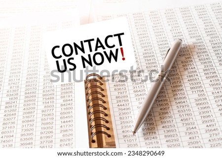 Text CONTACT US NOW on paper card, pen, financial documentation on table