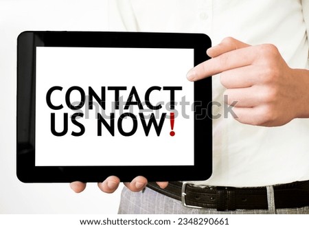 Text CONTACT US NOW on tablet display in businessman hands on the white background. Business concept