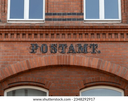 Postamt (post office) on an old building facade. Beautiful architecture in a German city. Close up of the exterior brick wall.