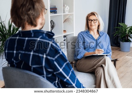 Professional psychotherapy. Female psychologist having session with male patient at mental health clinic, Taking Note During Appointment In Office. Psychological help service. Treatment of depression Royalty-Free Stock Photo #2348304867