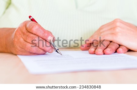 Photo of an elderly woman sign the testament Royalty-Free Stock Photo #234830848