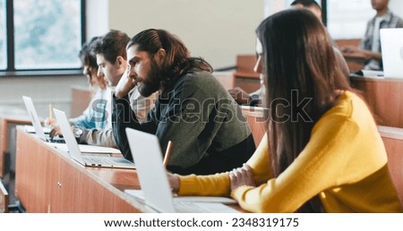 Bored students, males and females sittingat desk at college lesson and listening to professor. Educative concept. Indoor. Boring lection at University. Learning and sleping at seminar. Lazy guy. Royalty-Free Stock Photo #2348319175