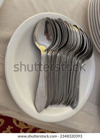 Top view of modern silver tea spoon in a white plate for weeding catering events potrait picture 