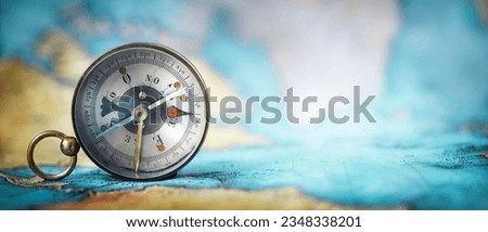 Magnetic old compass on world map.Travel, geography, navigation, tourism and exploration concept wide background. Macro photo. Very shallow focus. Royalty-Free Stock Photo #2348338201