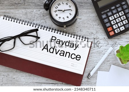 Payday advance top view of diary and desk clock. text on paper