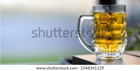 Glass of light beer on a wooden table in a restaurant