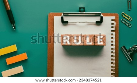 There is wood cube with the word RULE. It is as an eye-catching image.
