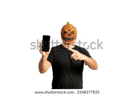 man in a Halloween pumpkin mask showing a smartphone on a white background