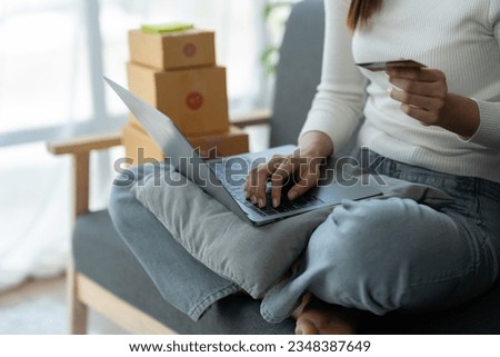 online shopping concept Freelance businesswoman with smartphone, laptop and bank card sitting on sofa thinking and searching for information on internet shopping ideas marketing e-commerce concept