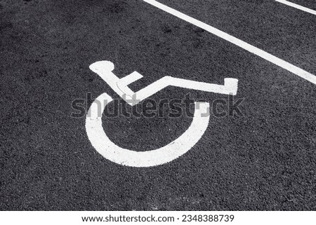 A symbol of a figure in a wheelchair marking out a reserved parkng space for disabled people
