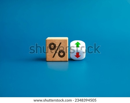 Percentage icon on wooden cube block and up and down arrow symbol on flipping white dice on blue background. Interest rate, financial stocks, ranking, GDP percent change, money exchange concepts. Royalty-Free Stock Photo #2348394505
