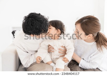 portrait of asian parent and daughter , family of three,kiss