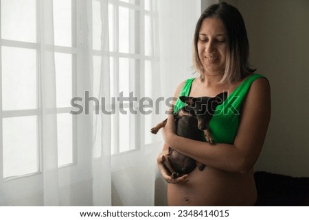 Pregnant woman in front of the window with a smile and a look of hope. Motherhood concept. Mother concept.