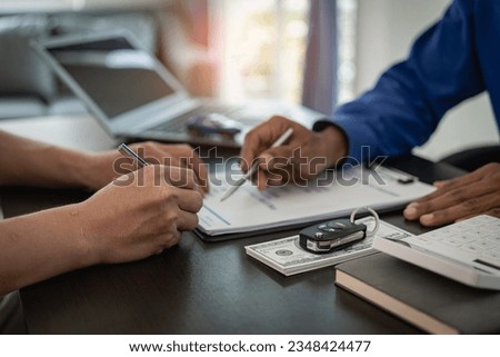 Signing a car insurance document or a rental agreement or agreement. Buy or sell a new or used car with car keys on the table in the office. close up pictures
