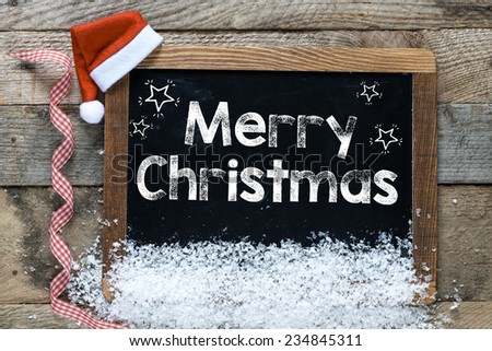 Christmas inscription on blackboard and decorations on wooden background