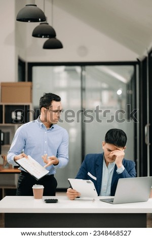 Furious two Asian businesspeople arguing strongly after making a mistake at work in modern office Royalty-Free Stock Photo #2348468527