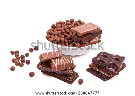 Various pieces of chocolate and a plate of chocolate balls isolated on white background