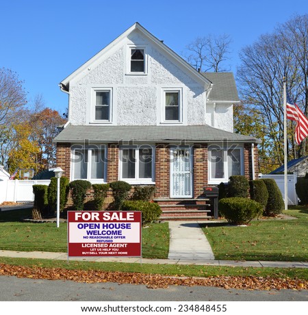 American Flag pole Real Estate For Sale Open House Welcome sign suburban gable front style home residential neighborhood clear blue sky USA