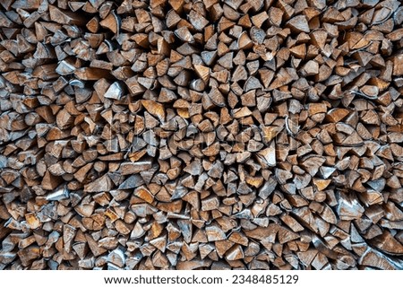 Background of stacked chopped wood logs. Pile of wood logs ready for winter. Wooden stumps, firewood stacked in heap. High quality photo