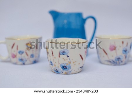 Mock up design- set of elegant and traditional tea set teapot colorful white and blue coffee cup and Tea cup on cup's plate beside the hot tea pot , design- drink-ware isolated on white background Royalty-Free Stock Photo #2348489203