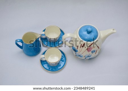 Mock up design- set of elegant and traditional tea set teapot colorful white and blue coffee cup and Tea cup on cup's plate beside the hot tea pot , design- drink-ware isolated on white background