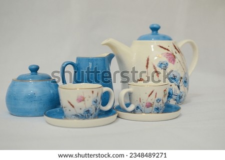 Mock up design- set of elegant and traditional tea set teapot colorful white and blue coffee cup and Tea cup on cup's plate beside the hot tea pot , design- drink-ware isolated on white background Royalty-Free Stock Photo #2348489271
