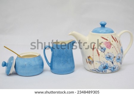 Mock up design- set of elegant and traditional tea set teapot colorful white and blue coffee cup and Tea cup on cup's plate beside the hot tea pot , design- drink-ware isolated on white background Royalty-Free Stock Photo #2348489305