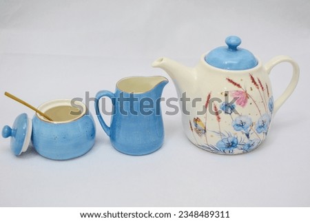 Mock up design- set of elegant and traditional tea set teapot colorful white and blue coffee cup and Tea cup on cup's plate beside the hot tea pot , design- drink-ware isolated on white background Royalty-Free Stock Photo #2348489311