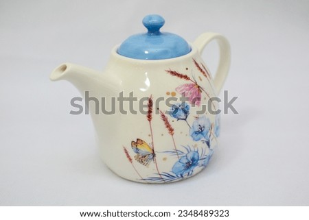 Mock up design- set of elegant and traditional tea set teapot colorful white and blue coffee cup and Tea cup on cup's plate beside the hot tea pot , design- drink-ware isolated on white background Royalty-Free Stock Photo #2348489323