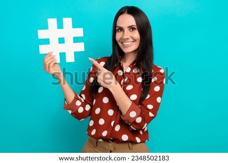 Portrait of smiling promoter trend manager smm content maker lady direct finger paper hash tag pin isolated on cyan color background