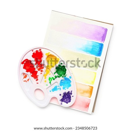 Palette and paper sheet with paints strokes on white background