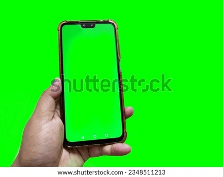 Hand holding smartphone with green screen background