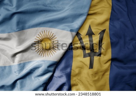 big waving realistic national colorful flag of argentina and national flag of barbados . macro