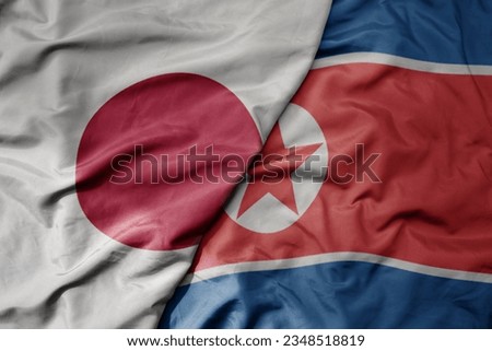 big waving realistic national colorful flag of japan and national flag of north korea . macro